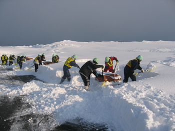 White Impulse team members shovel snow in areas their plows cannot reach.