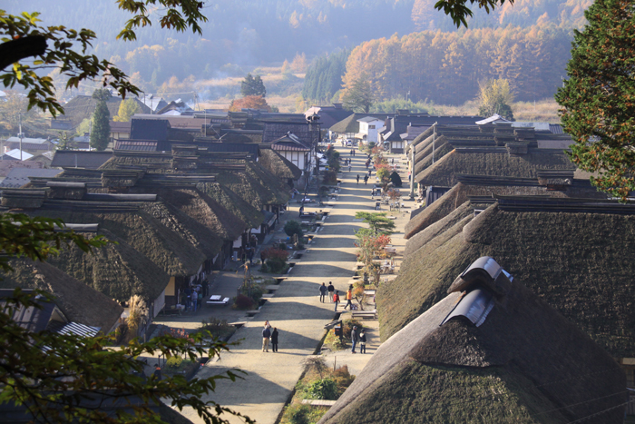 Traditional straw-roofed houses line a street in Ouchi-juku