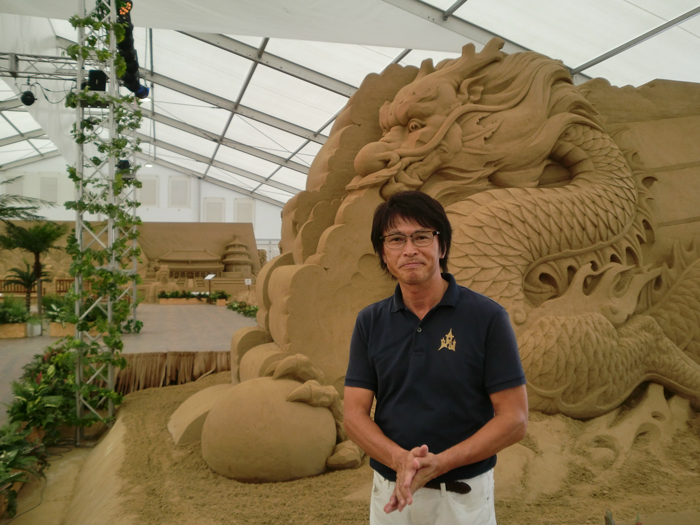  Japanese sand artist Katsuhiko Chaen talks about the sand art exhibition in the Kita-dori district near Bashamichi Station on Aug. 25.