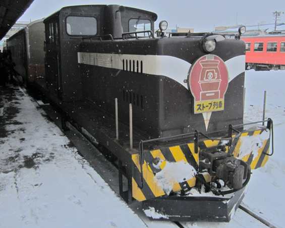 ﻿The stove train starting up from the terminal at Nakasato Station. The attached plow is used to clear snow from the tracks.
